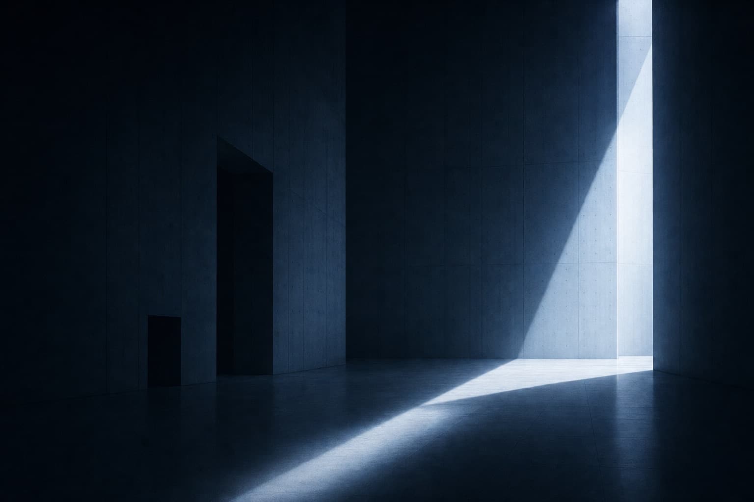Un atrio in cemento vuoto attraversato da una lama di luce fredda